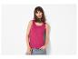 Frau in fuchsiafarbenem Tanktop und blauen Jeans, posiert mit der Hand in der Tasche.
