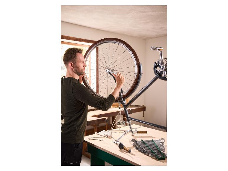 Ein Mann repariert ein Fahrrad mit dem PARKSIDE Gabelringschlüssel-Satz.