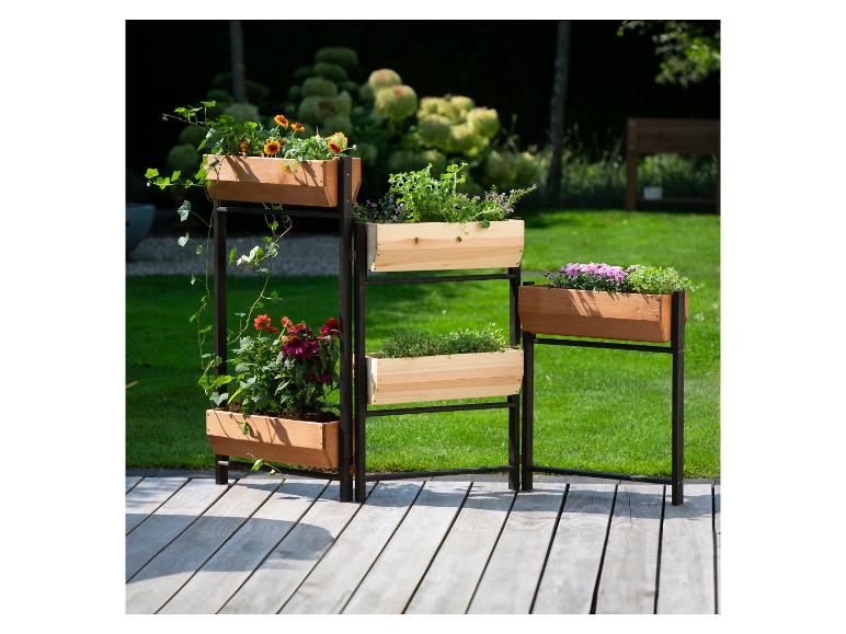 Gestuftes Holzhochbeet mit verschiedenen Blumen und Kräutern auf einer Terrasse.