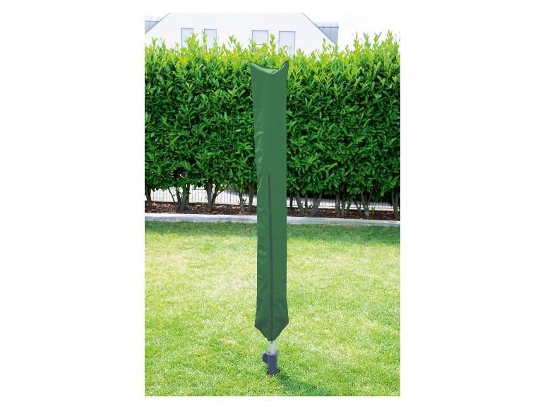 Grüne Wäschespinnenabdeckung in einem Garten mit Hecke und Haus im Hintergrund.