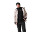 Mann in beiger Skijacke, schwarzem Fleece und Skihose mit Skibrille und Mütze