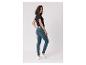 Frau in schwarzem T-Shirt und blauen Skinny Jeans, blickt über die Schulter.