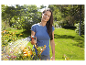 Frau bewässert Gartenblumen mit einer Gardena-Brause.