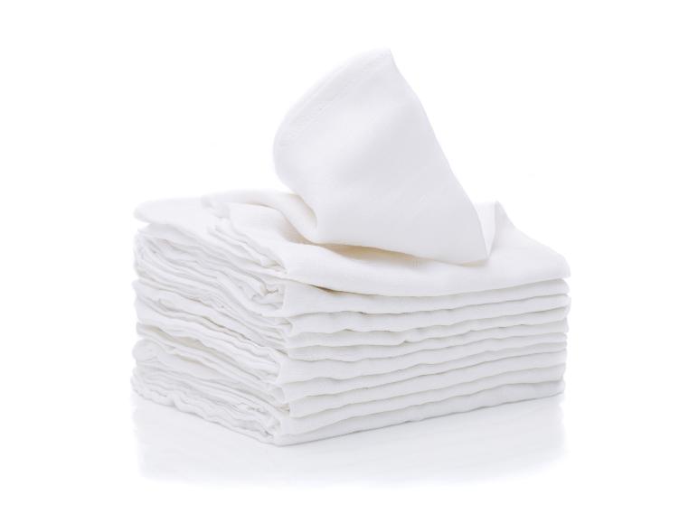 Stapel weißer Stoffwindeln oder Tücher mit einem gefalteten obenauf