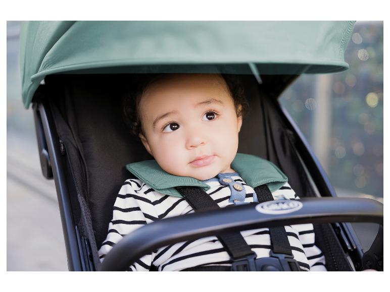 Baby im Kinderwagen, mit gestreiftem Hemd und grünem Kragen.
