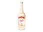 Flasche Sahnelikör mit Geburtstagskuchengeschmack, verziert mit Konfetti und einem Stück Kuchen.