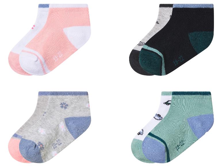 Vier Paar kurze Kindersocken in Rosa, Grau, Schwarz und Mintgrün mit Mustern.
