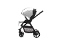 Schwarzer Kinderwagen mit verstellbarem Verdeck und Fußstütze, Pfeile zeigen die Bewegung an.