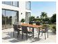 Gartenmöbel-Set: Tisch mit Holzplatte und sechs Stühle auf einer Terrasse.