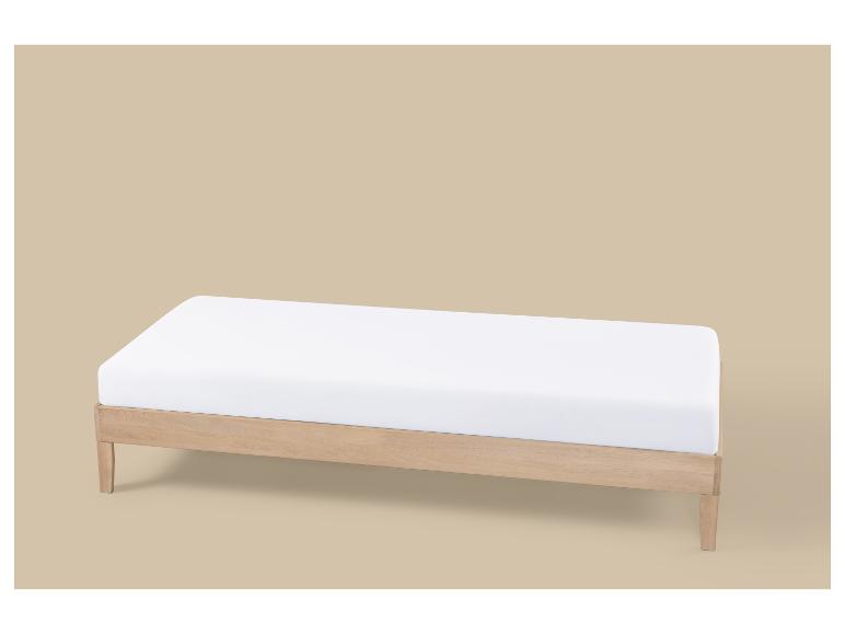 Holz-Tagesbett mit weißer Matratze auf beigem Hintergrund.