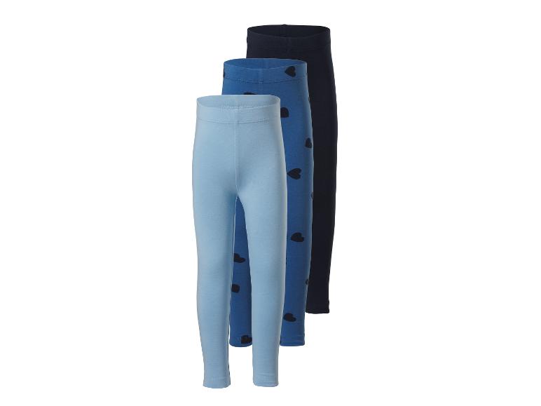 Drei Mädchen-Leggings in Blautönen, eine mit Herzen, auf weißem Hintergrund.
