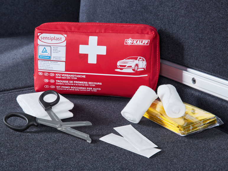 Eine rote Kalff Auto-Apotheke mit Bandagen, Gaze, einer Schere und anderem Zubehör.