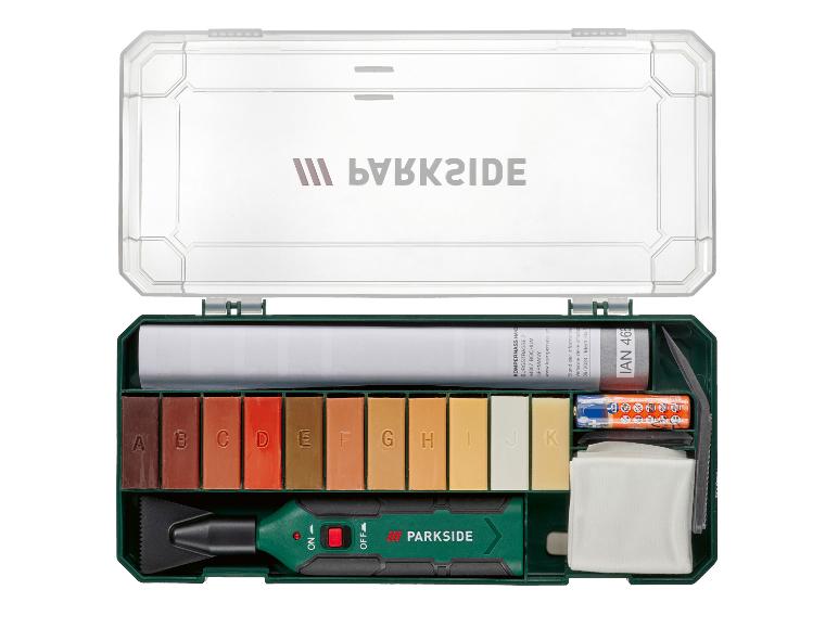 Ein Bodenreparaturset mit 11 farbigen Wachsstiften, einem Applikator und Zubehör in einer grünen Box.