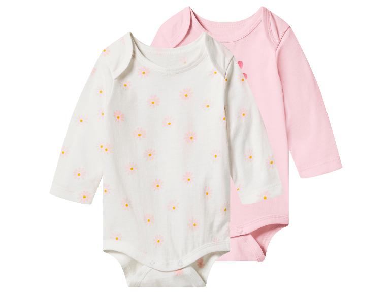 Zwei langärmelige Baby-Bodys: ein weißer mit rosa Gänseblümchen und ein einfarbiger rosa.