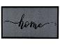 Graue Fußmatte mit schwarzem Rand und dem Schriftzug „home“.