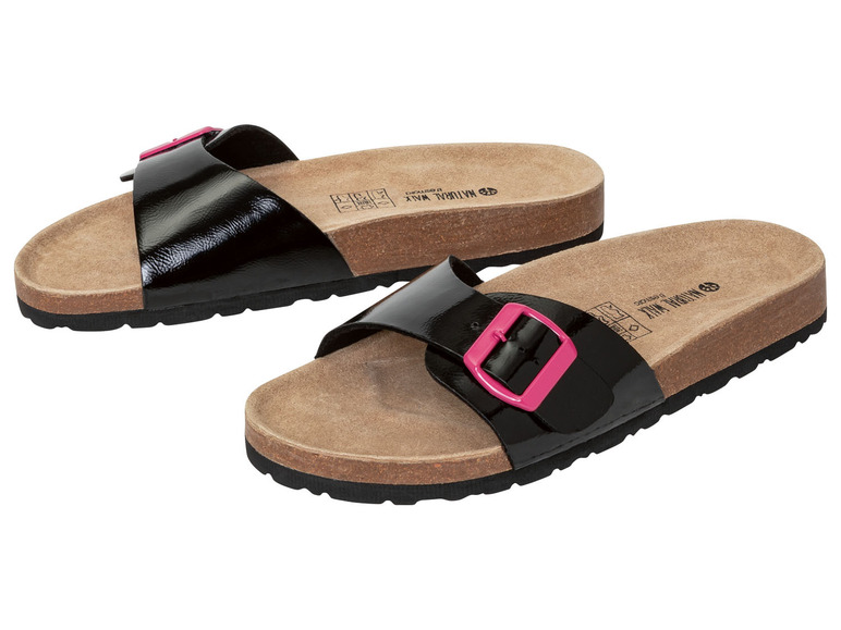Zwei Paar schwarze Pantoletten mit rosafarbenem Schnallenverschluss auf Korksohle.