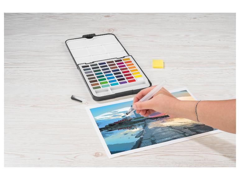 Eine Person malt eine Küstenszene mit Aquarellen und einem Wassertankpinsel.