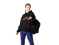 Frau in schwarzem Hoodie mit orangefarbenem Logo, blauen Leggings und schwarzer Sporttasche.