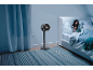 Standventilator in einem Schlafzimmer mit Mutter und Kind, die im Bett lesen.