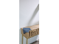 Blaues Küchentuch auf einer Holzkommode mit Lamellen vor einer weißen Wand.
