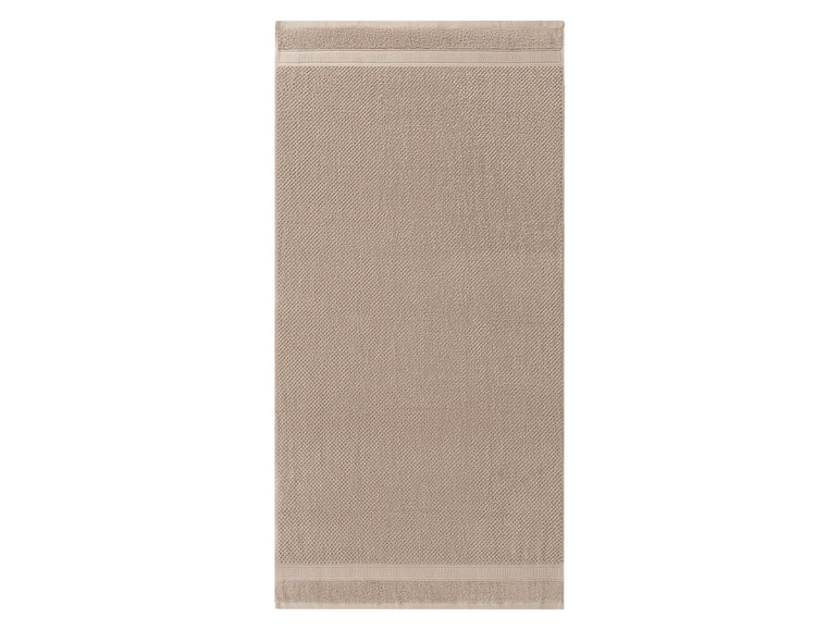 Eine beige Badezimmermatte mit Muster.