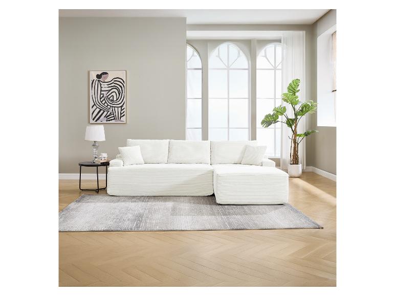 Weißes Modulsofa mit Kissen, Beistelltisch, Lampe und Topfpflanze in einem hellen Wohnzimmer.