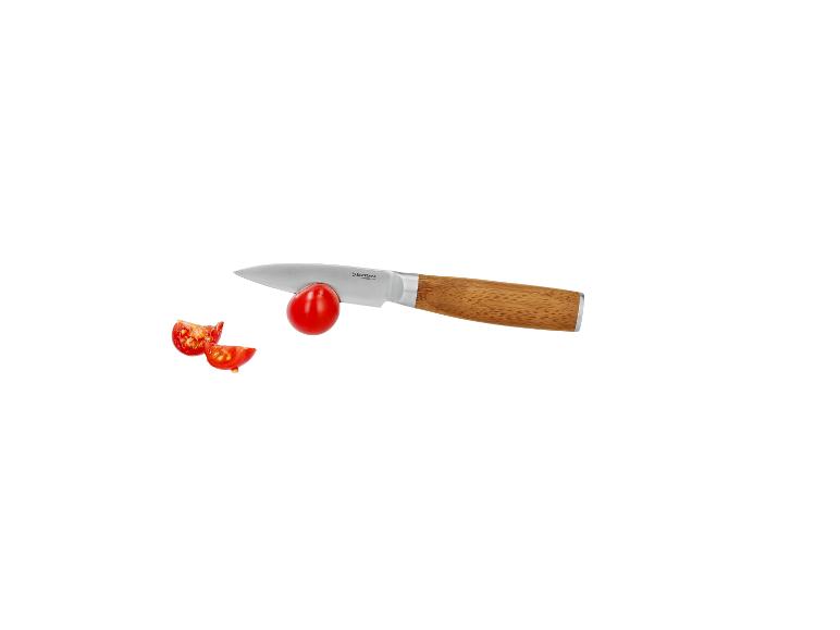 Schälmesser mit Holzgriff schneidet eine Kirschtomate