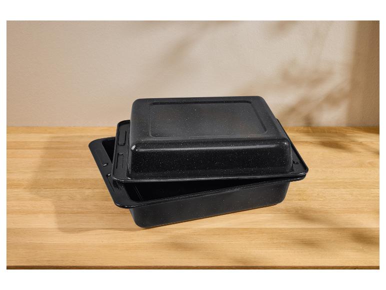 Zwei schwarze Bräter mit Deckeln, gestapelt auf einem Holztisch.