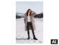 Frau im weißen ESMARA® Damen Strickpullover und Wintermantel im Schnee. [KI-generiertes Bild]
