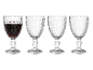 Vier Weingläser aus Glas mit Wabenmuster, eines mit Rotwein gefüllt.