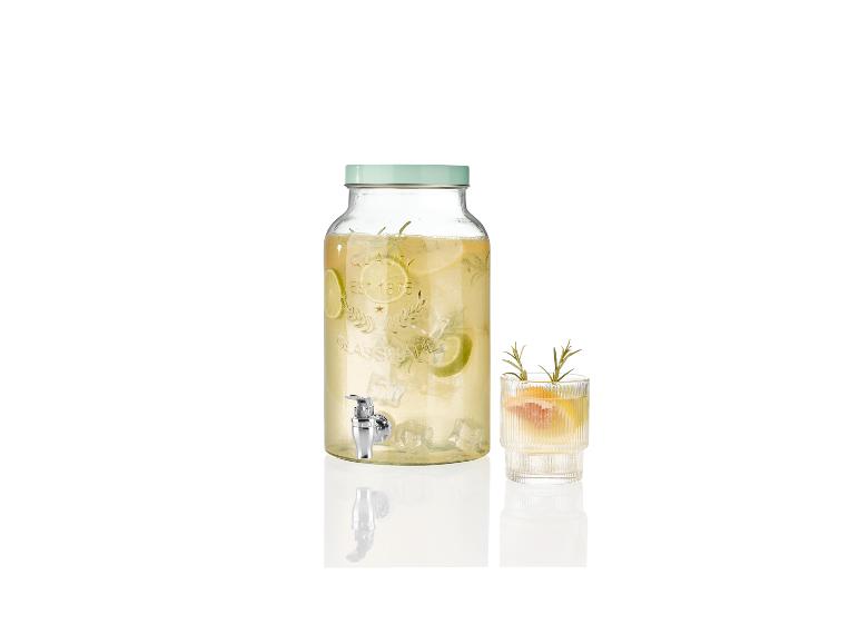 Getränkespender mit Hahn und Glas, erfrischende Limonade.