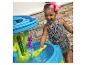 Lächelndes Mädchen spielt mit einem Wassertisch und Spielzeug.