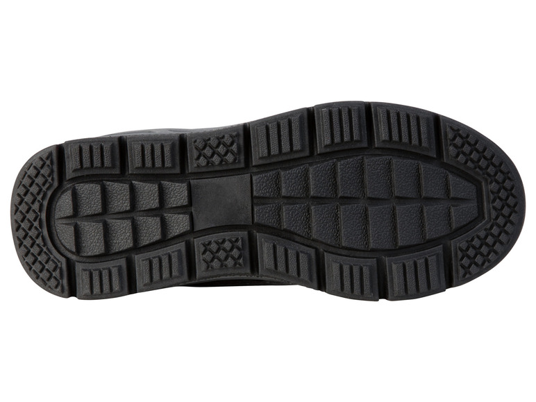 Die Sohle eines schwarzen Sneakers mit grobem Profil.