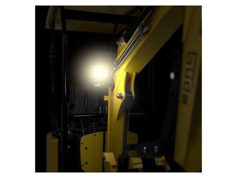 Nahaufnahme eines gelben Gabelstaplers mit hellem LED-Arbeitslicht auf dunklem Hintergrund.