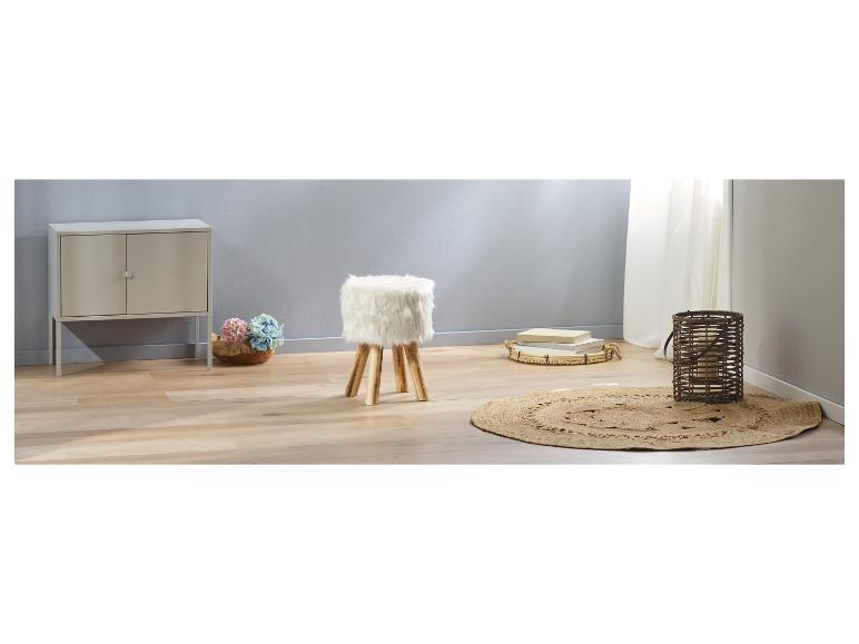 Ein weißer, flauschiger Hocker in einem Raum mit einem Jute Teppich.