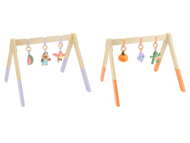 Zwei Baby-Holzspielbögen mit hängenden Plüschtieren, einer mit lila Akzenten, der andere mit orangefarbenen.