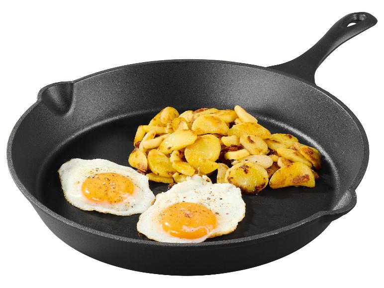 Spiegelei und Bratkartoffeln in einer gusseisernen Pfanne.