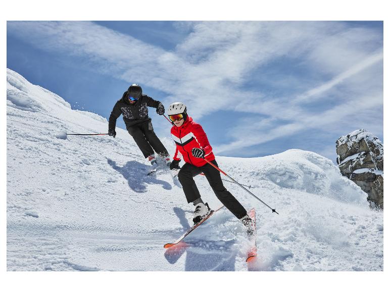 Zwei Skifahrer in Skijacken und Skihosen, die einen verschneiten Hang hinunterfahren.