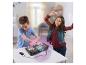 Zwei Kinder spielen mit einem DJ-Mischpult und einem Smartphone auf einem weißen Tisch.