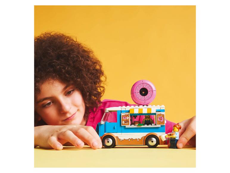 Ein Kind spielt mit einem LEGO Friends Donut-Foodtruck-Set.