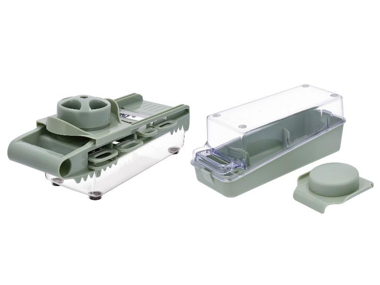 Grüner Gemüseschneider mit transparentem Behälter und Deckel.