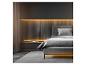 Modernes Schlafzimmer mit grauem Bett, beleuchtetem Holzkopfteil und transparentem Vorhang.