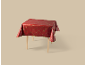 Rote Weihnachtstischdecke mit goldenen festlichen Mustern auf einem Holztisch.