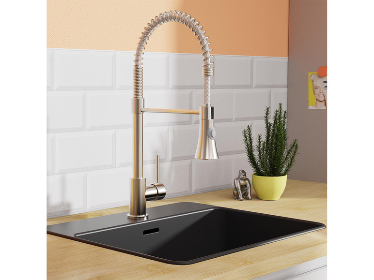 Ein moderner, silberfarbener Wasserhahn über einem schwarzen Spülbecken.