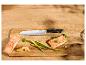 Lachs mit Spargel, Zitrone und einem Küchenmesser auf einem Holzschneidebrett.