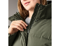 Nahaufnahme einer Frau in einer grünen Winterjacke mit halb geöffnetem Reißverschluss.