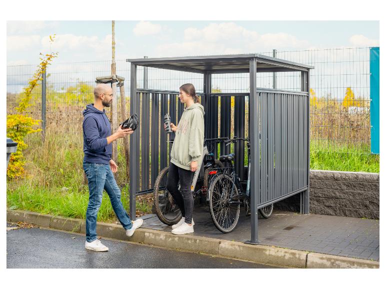 Mann und Frau an einem Fahrradständer mit zwei Fahrrädern.