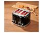 Schwarzer Toaster röstet Brot auf einem Holztisch, daneben Marmelade und Messer.