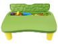 Grüner Kinderspieltisch mit gelben Beinen, gefüllt mit bunten Sandspielzeugen.