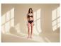 Frau in schwarzem BH und Slip, im Sonnenlicht stehend.